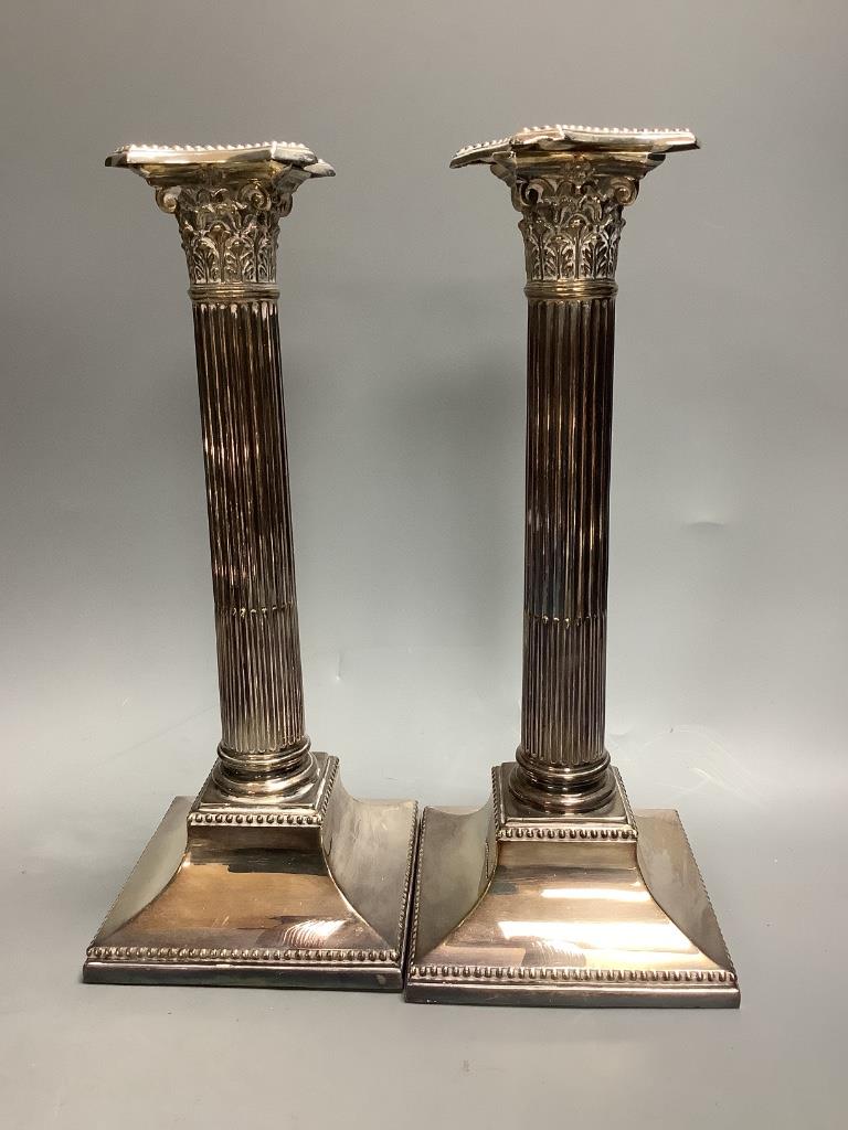 A pair of silver-plated Corinthian column candlesticks, height 28cm a small roll-top breakfast dish, a spoon warmer and five other plated items